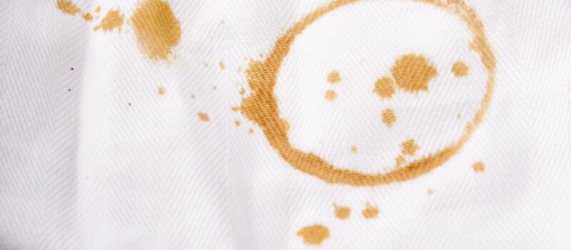 Onheilig - koffievlek op wit kleed_Freepik