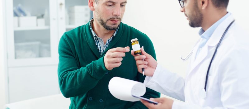 Doctor prescribing pills or vitamins to patient during medical consultation