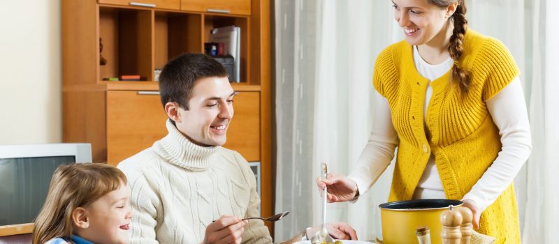 Happy woman serving soup for family in home_Bearfotos op Freepik