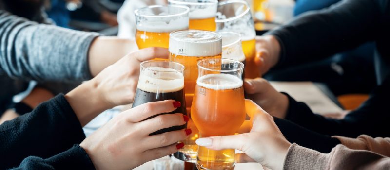 View of a group of people clinking glasses with beer