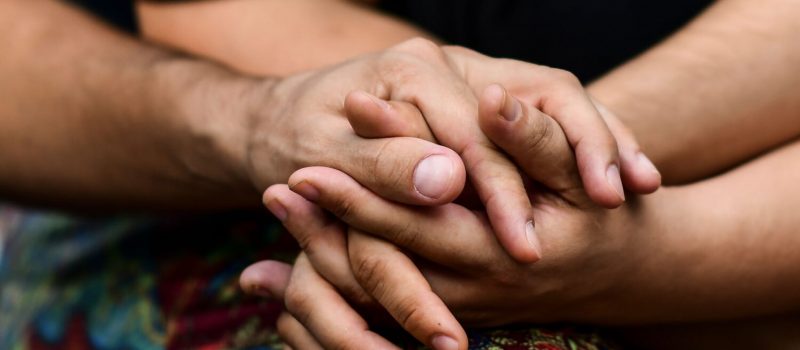 Mensen in een polyamoreuze relatie slaan de handen in elkaar in Buenos Aires. Bron: Getty Images/Ronaldo Schmidt/AFP